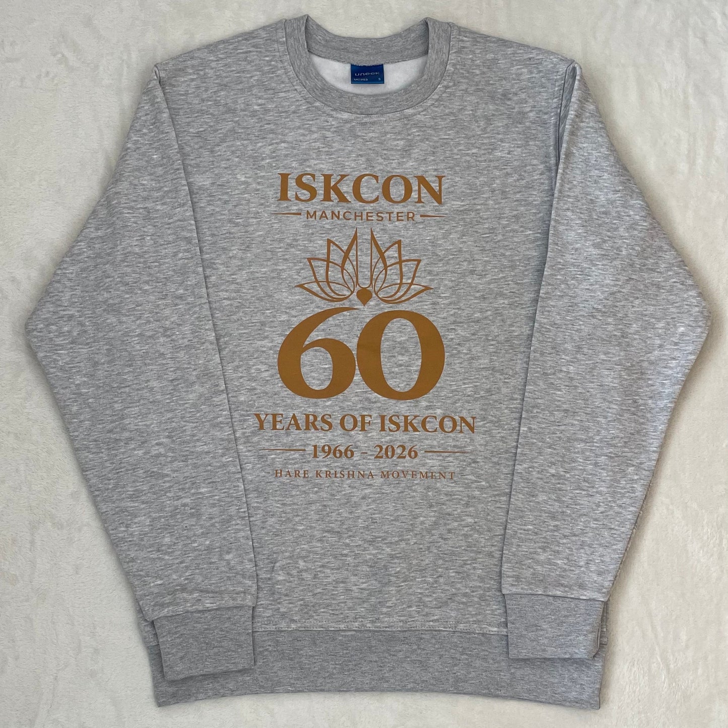 Gray sweatshirt with 'ISKCON Manchester 60 Years of ISKCON 1966-2026' printed on it.